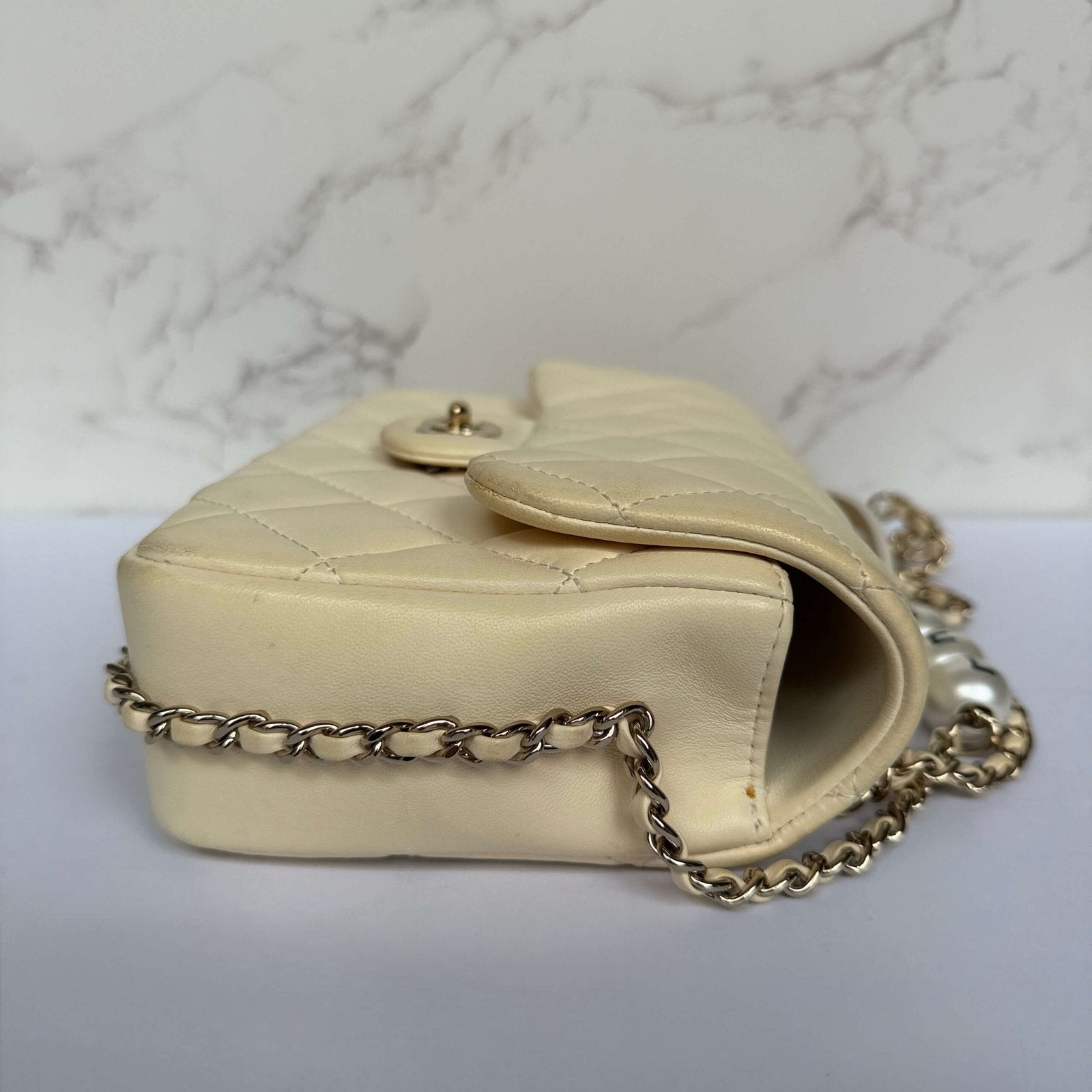 Zijkant authentieke Chanel my precious pearl chain flap