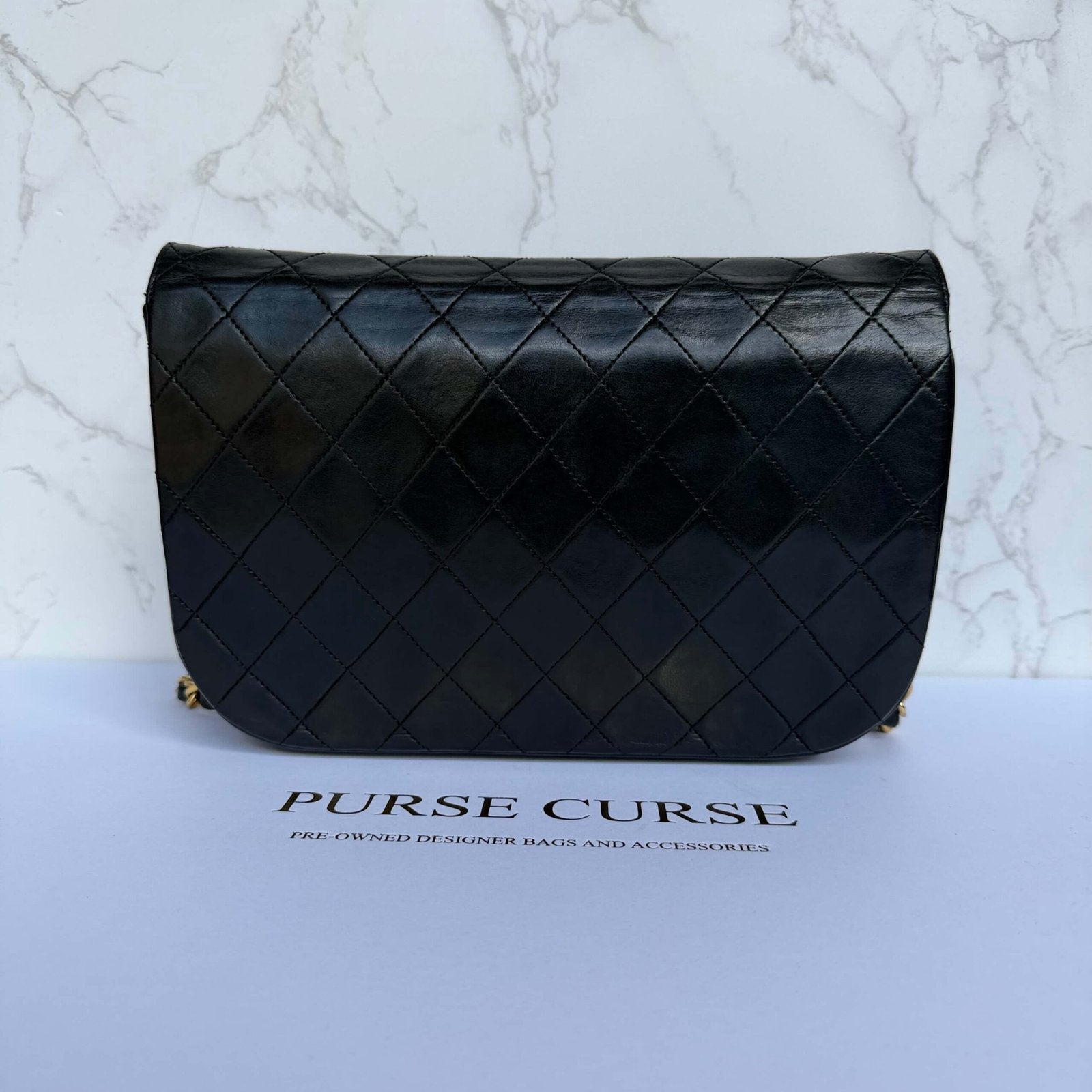 Achterkant authentieke Chanel tas double half moon flap zwart lamsleer