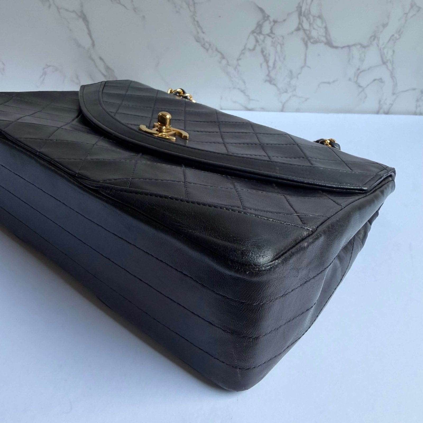Chanel vintage bag black with gold hardware close-up CC lock