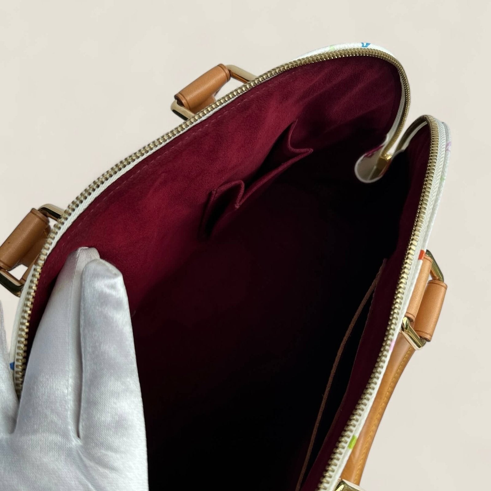 Inside a second hand Louis Vuitton multicolor Alma PM white canvas