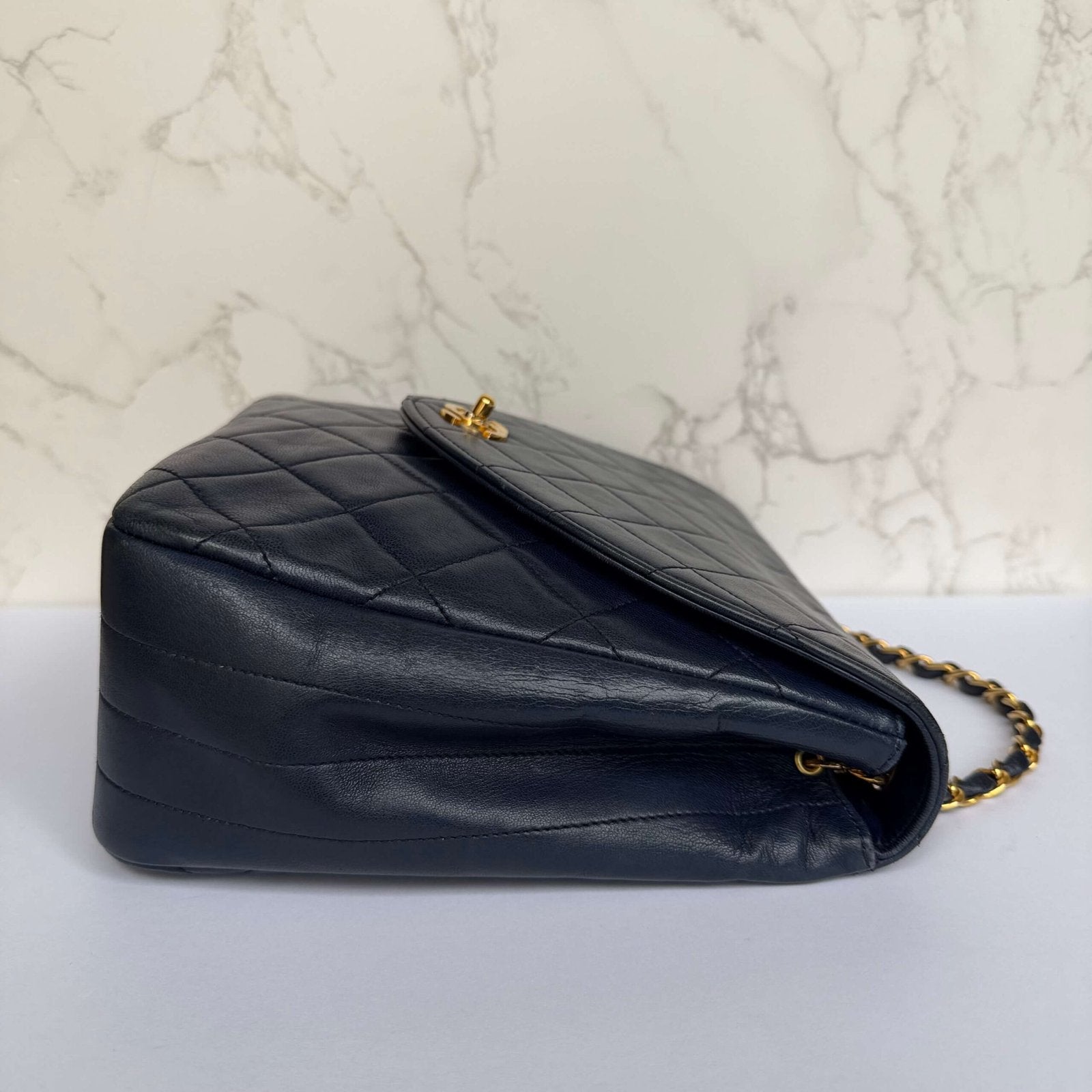 Zijkant originele Chanel single flap bag donkerblauw lamsleer