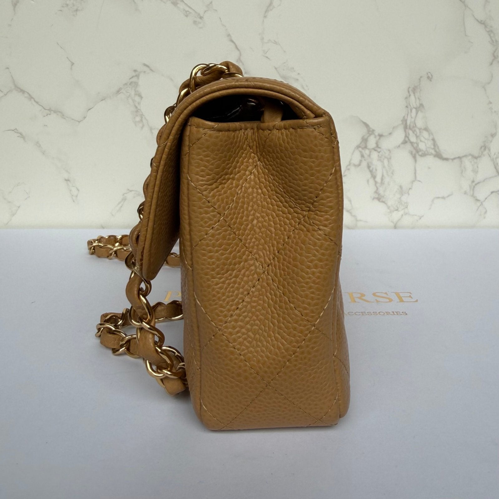 side vintage Chanel East West beige caviar flap