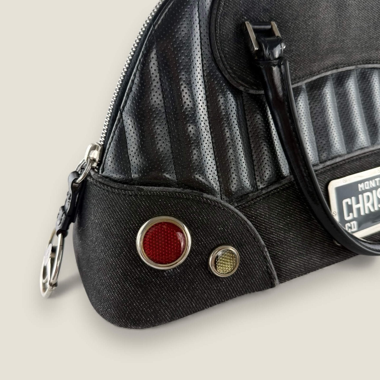 Silver-colored metal hardware and CD emblem inspired by classic Cadillac, characteristic of Dior John Galliano collections