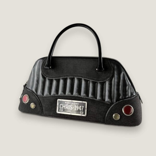 Zwarte vintage Dior Montaigne Chris 1947 Cadillac tas met iconisch CD logo op ritssluiting en geperforeerd leer.